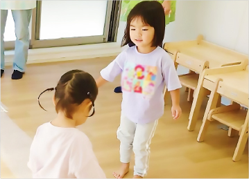 園児2名が向かい合い、遊ぶ中でコミュニケーションをとっている様子